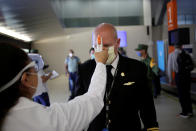 También hay nuevas medidas para la tripulación. En la imagen, una trabajadora revisa la temperatura a un piloto antes de que este tome un vuelo en el Aeropuerto Internacional Mariano Escobedo de Apodaca (México). (Foto: Daniel Becerril / Reuters).