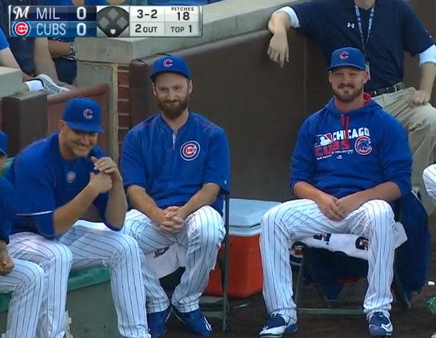 Travis Wood (far right) simply smiles after getting smacked by a foul ball. (MLB)