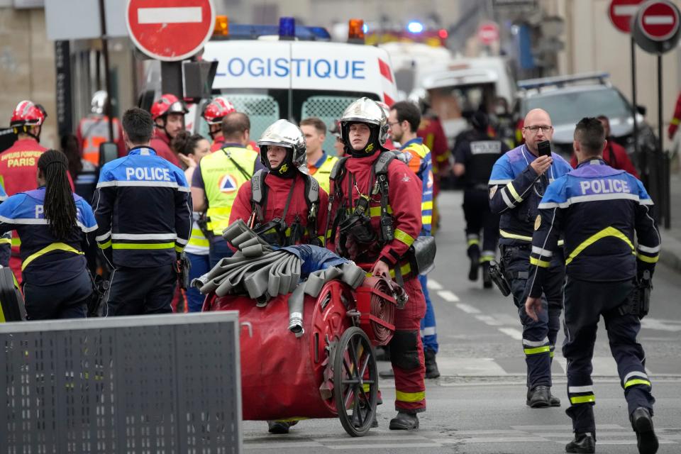 Police officers and rescue workers work at the site of a fire Wednesday, June 21, 2023 in Paris. A strong explosion hit a building in Paris' Left Bank on Wednesday, leaving four people injured and igniting a fire that sent smoke soaring over the domed Val de Grace monument and prompted the evacuation of buildings, police said. The cause of the blast was not immediately known.