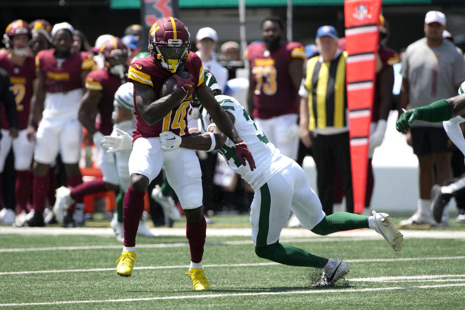 Washington Commanders wide receiver Olamide Zaccheaus, left, is stopped by New York Jets safety Al Blades Jr. after catching a pass during the first half of an NFL preseason football game Saturday, Aug. 10, 2024, in East Rutherford. N.J. (AP Photo/Pamela Smith)