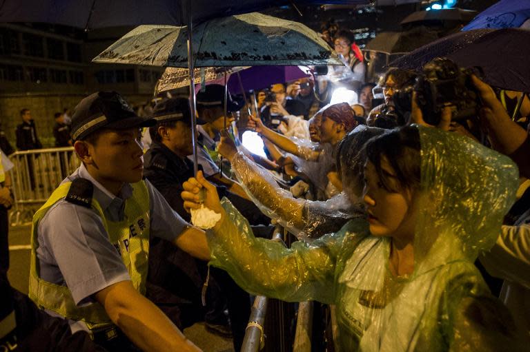 Pro-democracy protesters face policemen as they wait for Hong Kong chief executive Leung Chun-ying outside government offices on October 2, 2014