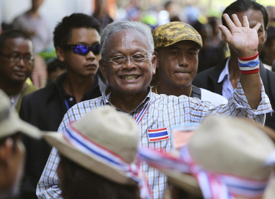 Anti-government protest leader Suthep Thaugsuban, center, waves to supporters while marching during a rally Thursday, May 8, 2014 in Bangkok, Thailand. A court ousted Thailand's Prime Minister Yingluck Shinawatra for abuse of power, accomplishing what anti-government demonstrators have sought to do for the past six months and further widening the country's sharp political divide. Suthep told his followers that they would stage a "final offensive" on Friday and would achieve their goal of fully ousting the government. (AP Photo/Apichart Weerawong)