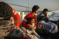Migrants sit on a Turkish coast guard vessel after they were pulled off life rafts, during a rescue operation in the Aegean Sea, between Turkey and Greece, Saturday, Sept. 12, 2020. Turkey is accusing Greece of large-scale pushbacks at sea — summary deportations without access to asylum procedures, in violation of international law. The Turkish coast guard says it rescued over 300 migrants "pushed back by Greek elements to Turkish waters" this month alone. Greece denies the allegations and accuses Ankara of weaponizing migrants. (AP Photo/Emrah Gurel)