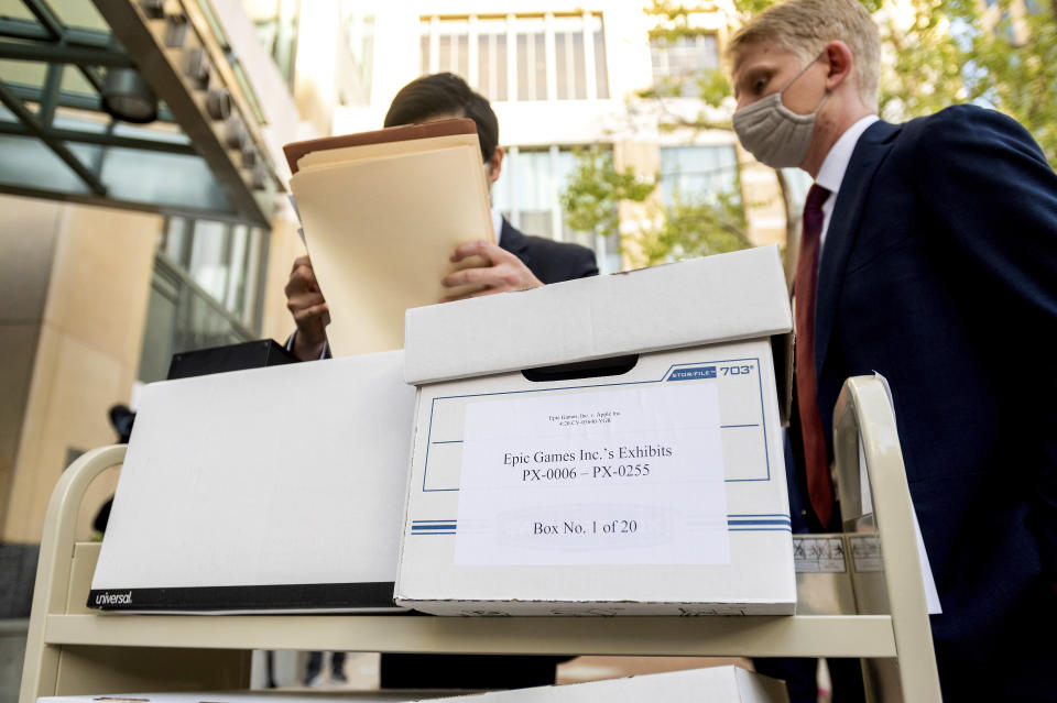 Members of Epic Games' legal team roll exhibit boxes into the Ronald V. Dellums building in Oakland, Calif., for the company's lawsuit against Apple on Monday, May 3, 2021. Epic, maker of the video game Fortnite, charges that Apple has transformed its App Store into an illegal monopoly. (AP Photo/Noah Berger)