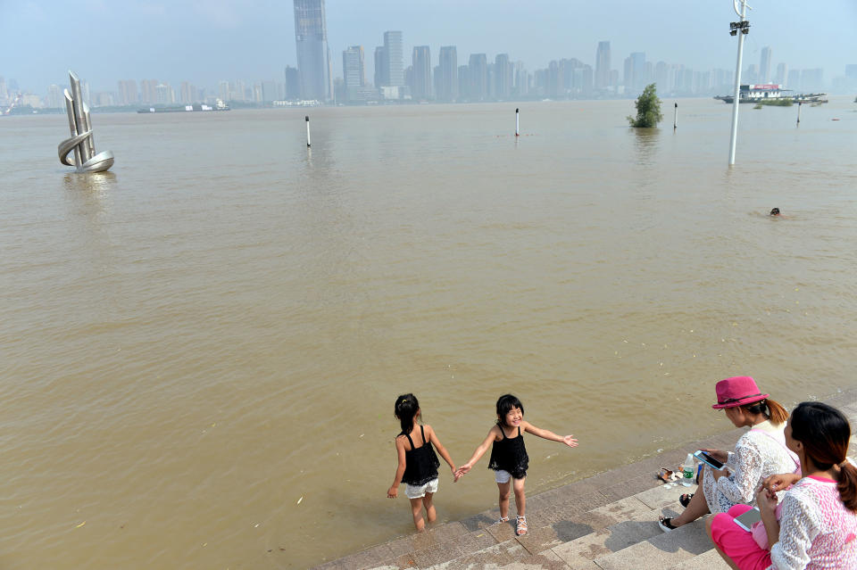 <p>People spend time at a flooded bank of the Yangtze River in Wuhan, Hubei province, China, July 3, 2017. (Photo: Stringer/Reuters) </p>