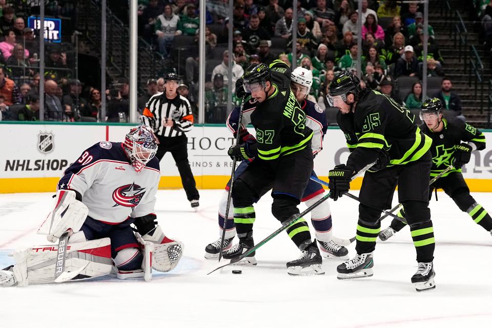 Columbus Blue Jackets goaltender Elvis Merzlikins (90) defends the net against pressure from Dallas Stars left wing Mason Marchment (27) and center Matt Duchene (95) in the first period of an NHL hockey game, Monday, Oct. 30, 2023, in Dallas. (AP Photo/Tony Gutierrez)