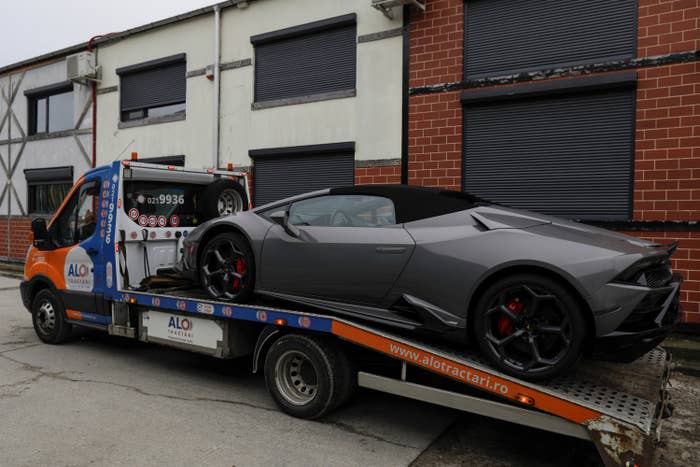 Romanian officials transport the cars seized from the Tate compound to an undisclosed storage location, from Voluntari, Ilfov, Romania, Jan. 14.