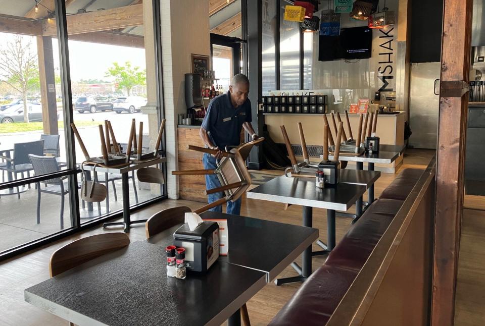 Longtime employee Royce Fedd sets up tables at M Shack, 10281 Midtown Parkway, in St. Johns Town Center on Saturday, March 16, 2024. The restaurant closed permanently on Sunday.