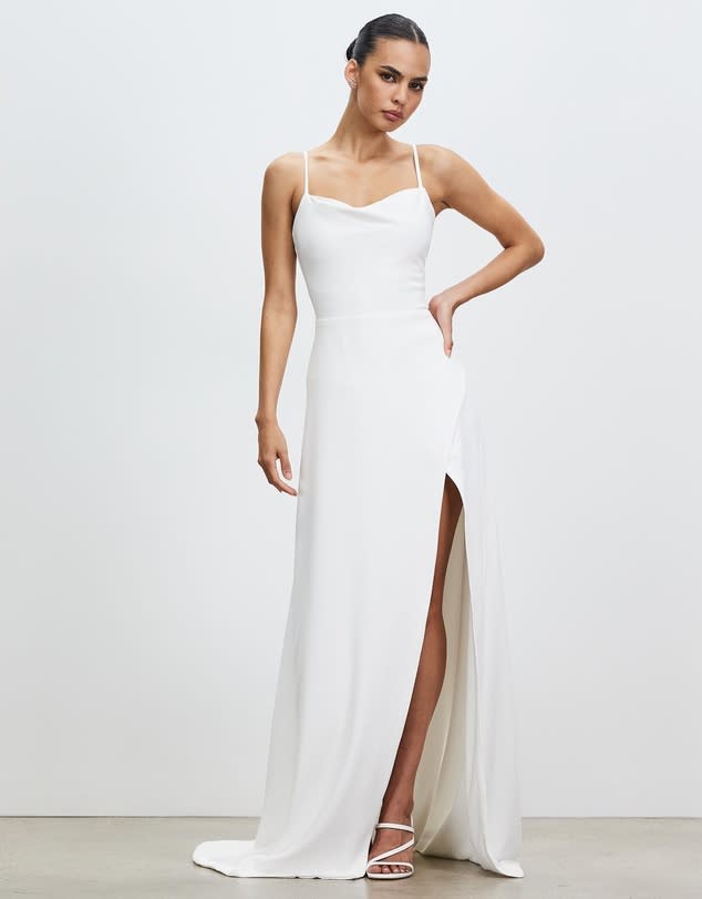 Woman in long white strappy wedding dress with split.