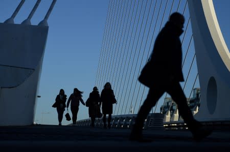 FILE PHOTO: Commuters make their way into work in the morning in the financial district of Dublin