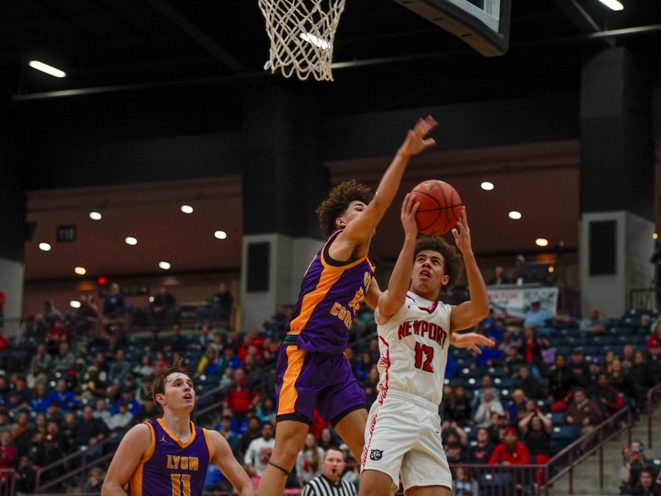 Newport freshman Amontae Lowe (12) goes up for a layup while getting fouled by Lyon County's Bray Kirk (10) in the second half of the All "A" Classic state semifinal game on Jan. 27 at Corbin Arena in Corbin, Ky.
