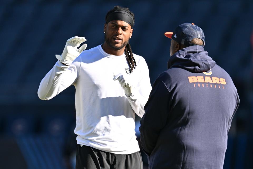 Las Vegas Raiders wide receiver Davante Adams (17) talks with a member of the Chicago Bears staff before their game at Soldier Field.