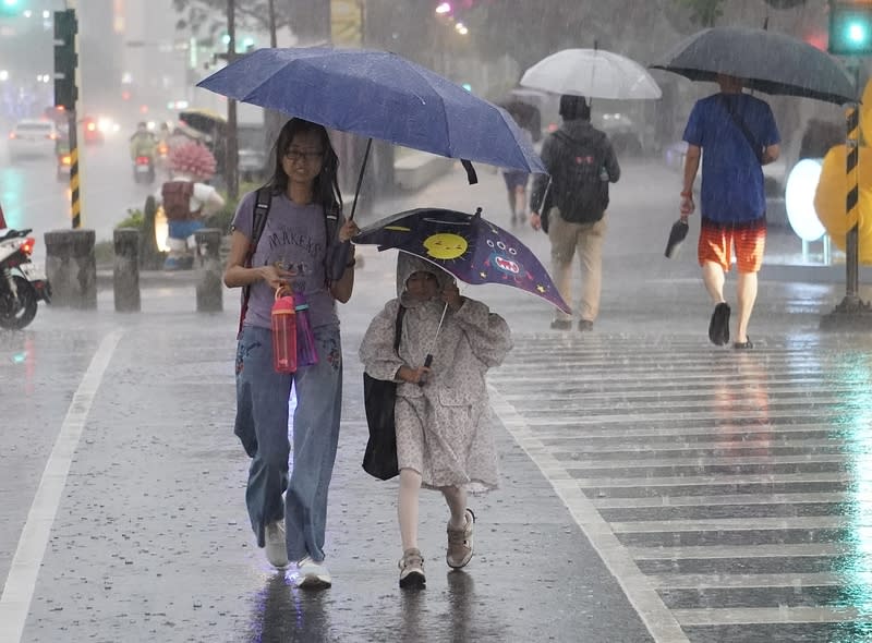 高雄傍晚下起陣雨（1） 中央氣象署24日下午持續針對多個縣市發布大雨特 報，受鋒面影響，高雄市新興區傍晚出現不小雨勢， 民眾撐傘過馬路。 中央社記者董俊志攝  113年4月24日 