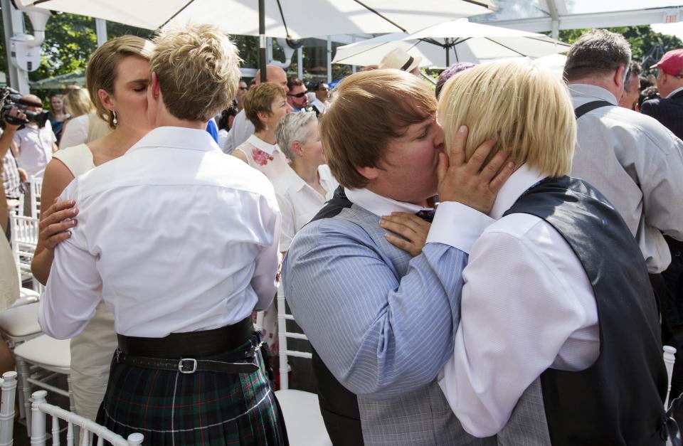 Couples kiss during the "Celebration of Love" grand wedding where over 100 LGBT couples got married at Casa Loma in Toronto