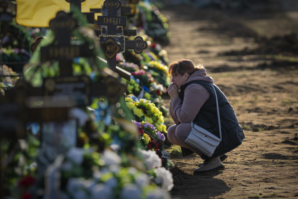Tamara, 50, mourns at the grave of her only son, a military servicemen killed during a Russian bombing raid, at a cemetery in Mykolaiv, Ukraine, on Wednesday, Oct. 26, 2022. Tamara did not learn of her son's death until four months after he died, when she managed to escape from her village in Kherson occupied by Russian troops. (AP Photo/Emilio Morenatti)
