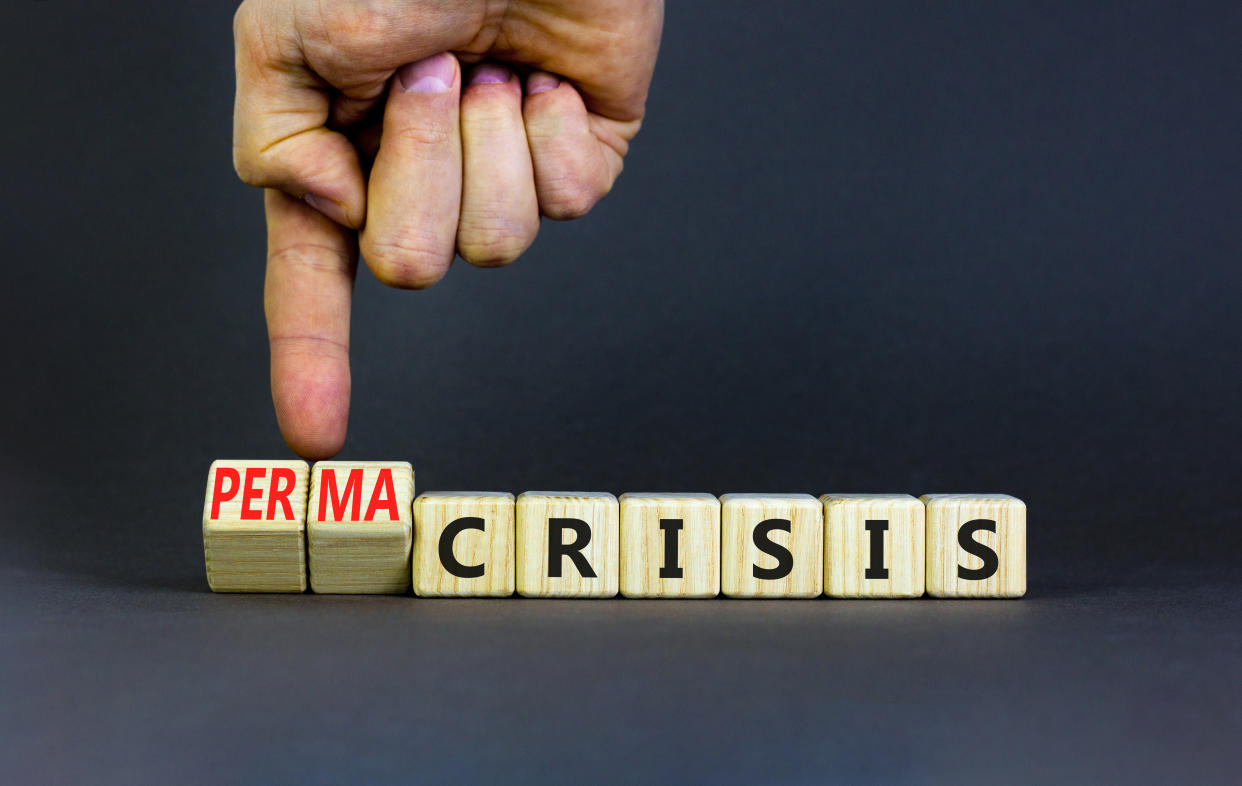 Permacrisis or crisis symbol. Concept words Crisis and Permacrisis on wooden cubes. Businessman hand. Beautiful grey table grey background. Business permacrisis or crisis concept. Copy space.