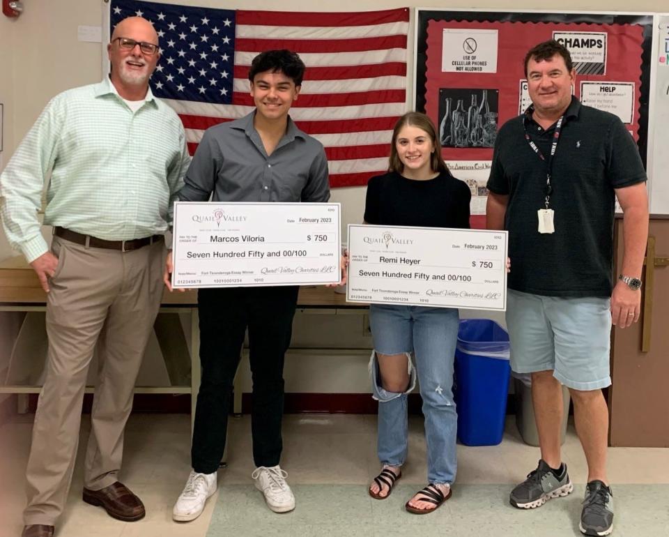 Vero Beach High School Principal Shawn O'Keefe, left, and AP History teacher Jeremy Pohl flank Marcos Viloria and Remi Heyer, who won $750 scholarships from Quail Valley Charities for their essays about a presentation made by the Fort Ticonderoga Association in early 2023.