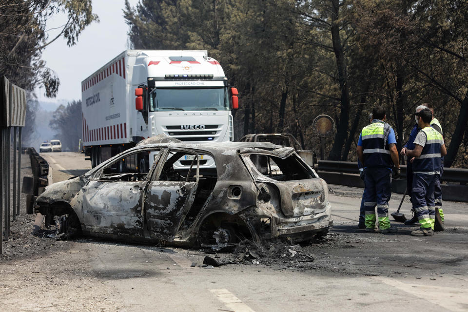 <p>A Portuguese Civil Protection refrigerated truck arrives to transport the bodies of victims near burned cars on a road between Figueiro dos Vinhos and Castanheira de Pera, Pedrogao Grande, central Portugal, June 18, 2017. At least 62 people have been killed in forest fires in central Portugal, many of them trapped in their cars as flames swept over a road Saturday evening. (Paulo Novais/EPA/Rex/Shutterstock) </p>