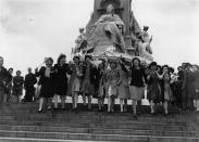 A group of London girls waving flags in front of the statue of Queen Victoria outside Buckingham Palace on VE Day, 8th May 1945. (Photo by Keystone/Hulton Archive/Getty Images)