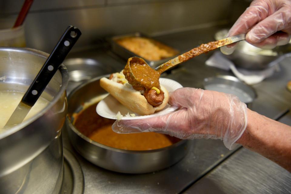 Fulvio "Phil" Grosso, owner of Johnny and Hanges in Fair Lawn, where "all the way" Texas weiners are served, prepares one for an order.