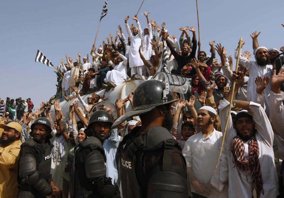 Supporters of the Jamiat Ulema-e-Islam party wave to greet their leader arrives to lead an anti-government march, in Karachi, Pakistan, Sunday, Oct. 27, 2019. Thousands of supporters of the ultra-religious party are gathering in Karachi to start a large anti-government march on Pakistan's capital farther north. (AP Photo/Fareed Khan)
