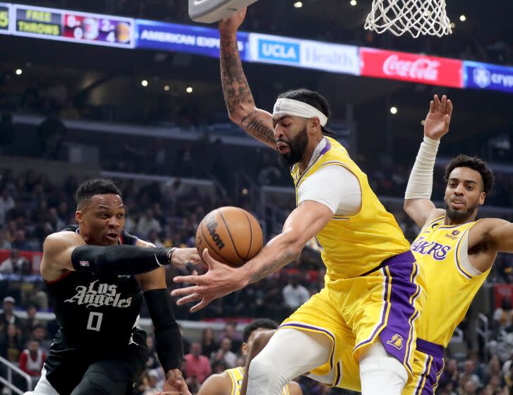 Los Angeles, CA - April 05: Clippers guard Russell Westbrook turns the ball over to Lakers power forward Anthony Davis in the first quarter Tuesday night, Apr. 5, 2023, at Crypto.com Arena. (Luis Sinco / Los Angeles Times)