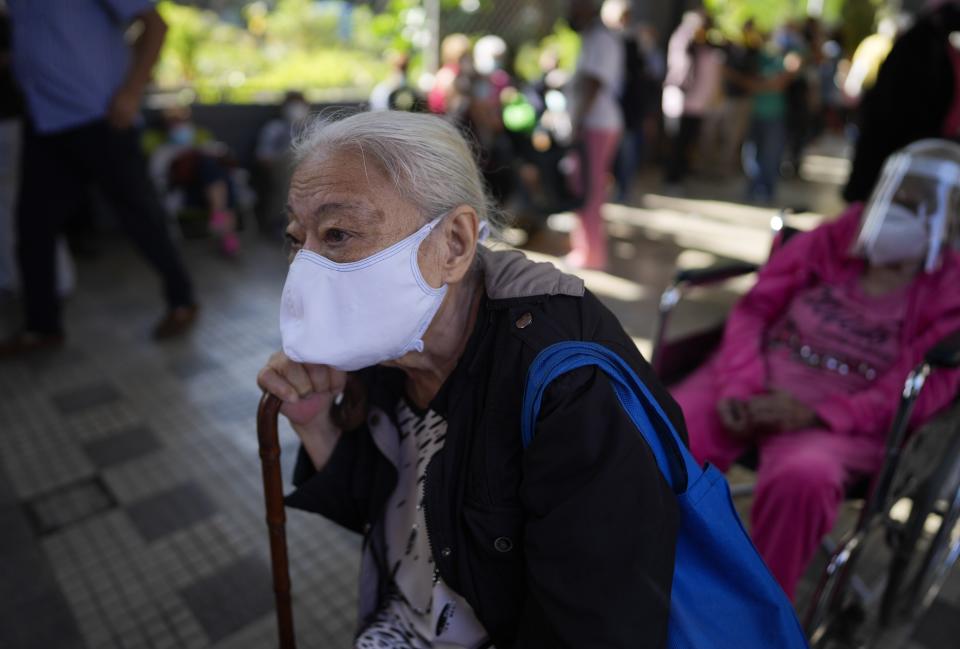 A elderly woman waits outside of a vaccination center looking to be inoculated with a second dose of the Sputnik V COVID-19 vaccine, in Caracas, Venezuela, Thursday, Sept. 16, 2021. The Venezuelan government is beginning rollouts of second doses following months of delays. (AP Photo/Ariana Cubillos)