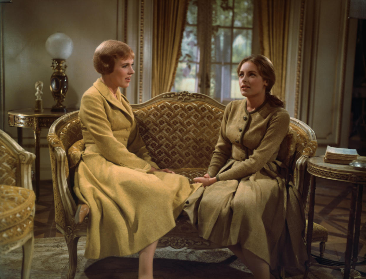 Julie Andrews as Maria von Trapp sits on a sofa with Charmian Carr as Liesl von Trapp in the film adaption of the Rogers and Hammerstein musical The Sound of Music.