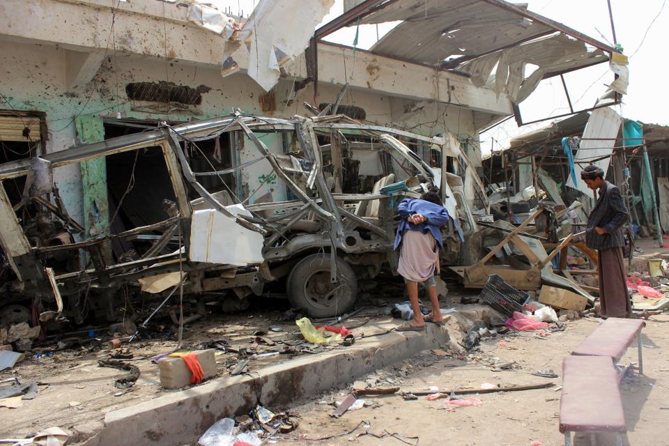 <p>Yemenis gather next to the destroyed bus at the site of a Saudi-led coalition air strike, that targeted the Dahyan market the previous day in the Huthi rebels’ stronghold province of Saada on Aug. 10, 2018. (Photo: Stringer/AFP/Getty Images) </p>