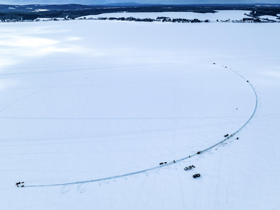 This photo provided by Aroostook UAS shows volunteers creating a giant ice carousel on a frozen lake work on a path curt through the ice on Wednesday, March 29, 2023 on Long Lake in Madawaska, Maine. (Aroostook UAS via AP)