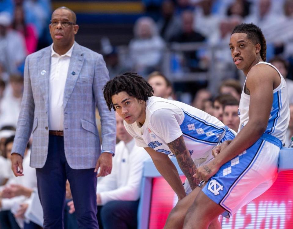 North Carolina head coach Hubert Davis looks on as Armando Bacot, right, and Elliot Cadeau wait to check into the Tar Heels’ game against Tennessee last month. UNC won 100-92.