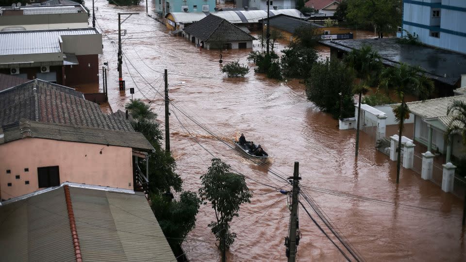 Volunteers use a fishing boat to rescue residents trapped inside their houses in São Sebastião do Cai, Rio Grande do Sul state. - Anselmo Cunha/AFP/Getty Images