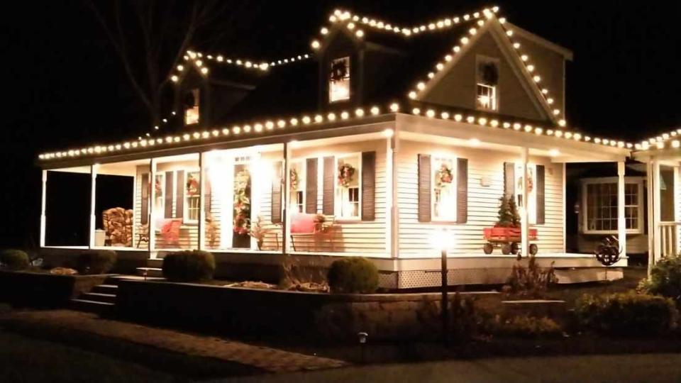 All lit up for Christmas: A view of the wrap-around porch at 67 Poquanticut Ave. in Easton. A tree fell and destroyed the porch in a July 29, 2023 storm in which a tornado touched down.