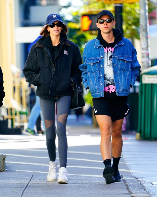 Kaia Gerber walks in the blue jacket and brown leggings