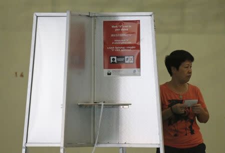 A voter prepares to cast her ballot during the general election at a polling center in Singapore September 11, 2015. REUTERS/Edgar Su