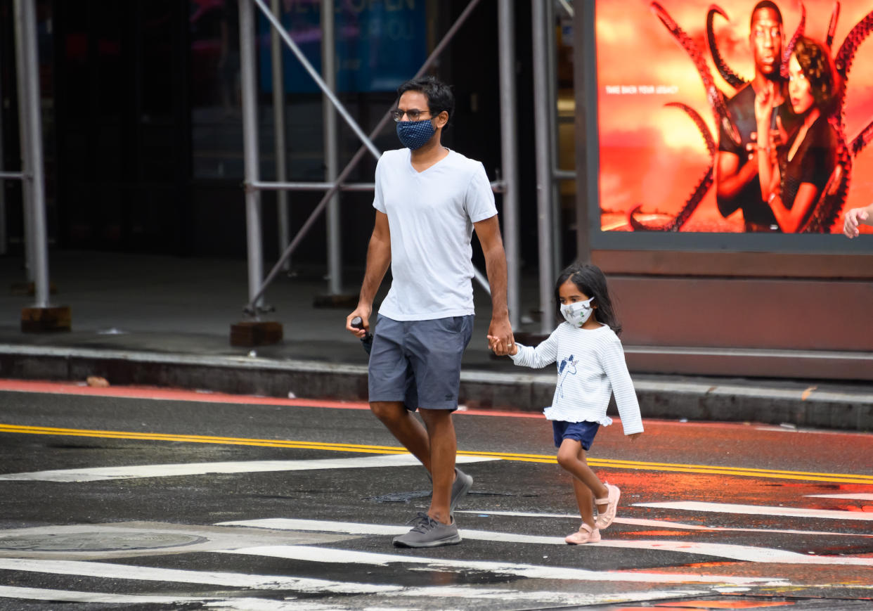 NEW YORK, NEW YORK - AUGUST 16: People wear protective face masks in Hell's Kitchen as the city continues Phase 4 of re-opening following restrictions imposed to slow the spread of coronavirus on August 16, 2020 in New York City. The fourth phase allows outdoor arts and entertainment, sporting events without fans and media production. (Photo by Noam Galai/Getty Images)