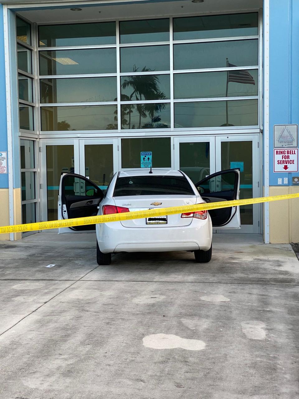 A white Chevrolet Cruze, with a rear windshield that appears to have a bullet hole, is pictured in front of the entrance to the Stuart Police Department, Sunday, Sept. 3, 2023. Police said the teen driver had been shot nearby, around 5 p.m., and nearly crashed his car into the building shortly afterward, seeking medical attention.