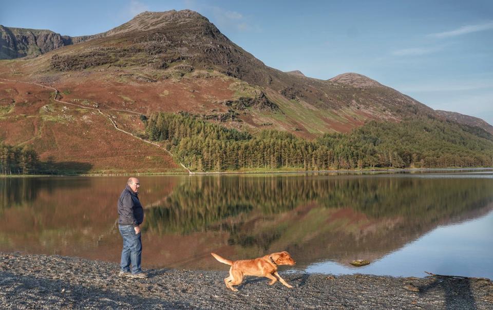 A man walking his dog in Cumbria (Owen Humphreys/PA) (PA Archive)