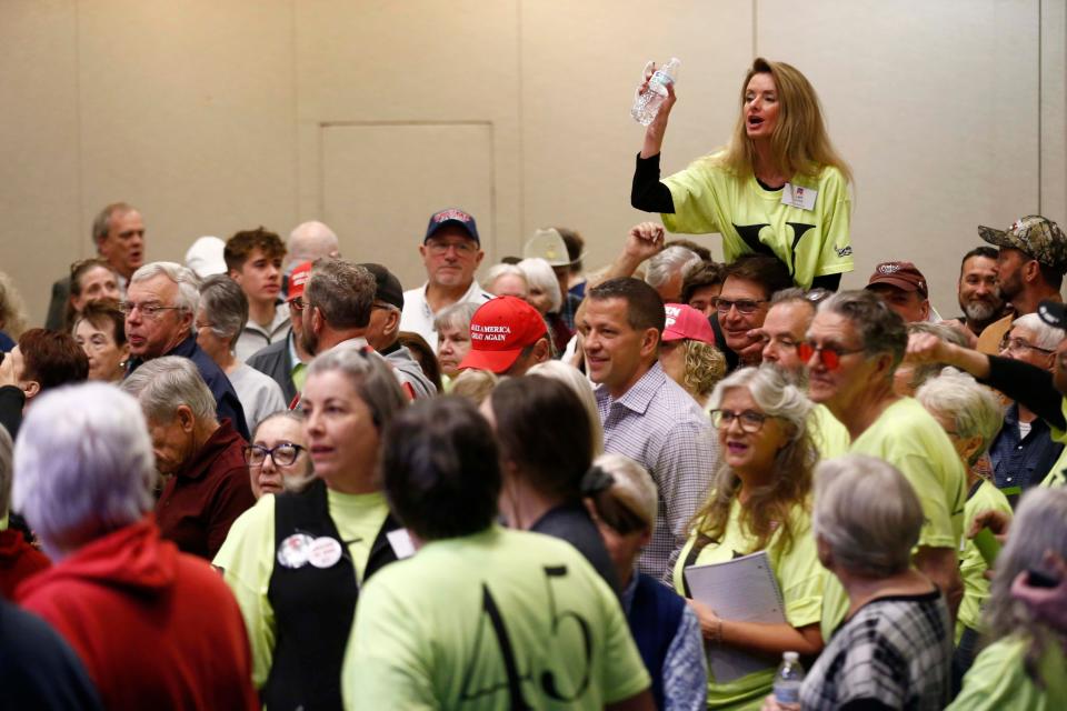 Lori Kaczmarek directs those supporting Donald Trump during the Greene County Republican Caucus at the Oasis Convention Center in north Springfield on March 2, 2024.