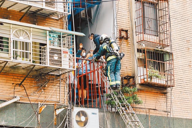 高雄城中城大火造成46人慘死，全台大樓全面安檢，台北市消防局21日在信維大樓舉行演練，圖為消防人員架梯搶救受困民眾。（郭吉銓攝）
