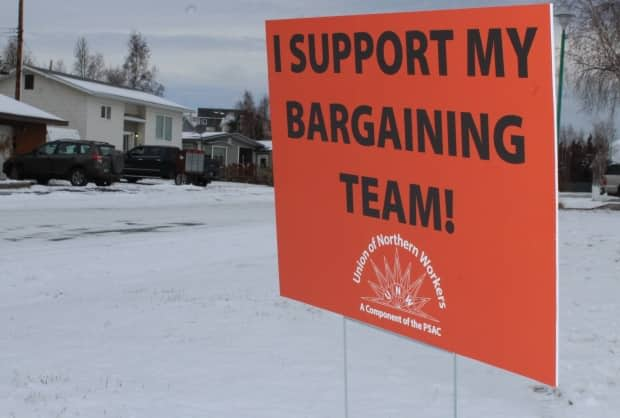 Signs of support for the Union of Northern Workers seen in Yellowknife in 2018. On Monday, the territory and the union said they've reached a tentative agreement. (Michael Hugall/CBC  - image credit)