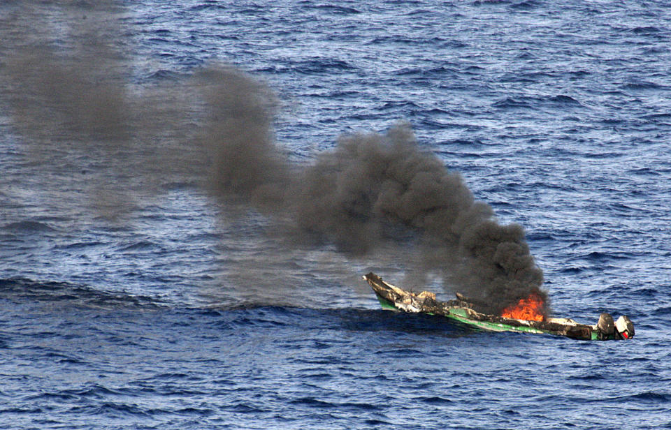 FILE - In this Saturday, April 10, 2010 file photo released by the U.S. Navy, a suspected pirates' skiff burns after being destroyed near the amphibious dock landing ship USS Ashland, part of the Nassau Amphibious Ready Group and 24th Marine Expeditionary Unit, at sea in the Gulf of Aden, about 330 nautical miles off the coast of Djibouti. World sea piracy fell for a third straight year in 2013, as Somali pirates were curbed by international naval patrols and improved ship vigilance, an international maritime watchdog said Wednesday, Jan. 15, 2014. (AP Photo/U.S. Navy, Chief Fire Controlman Harry J. Storms, File)