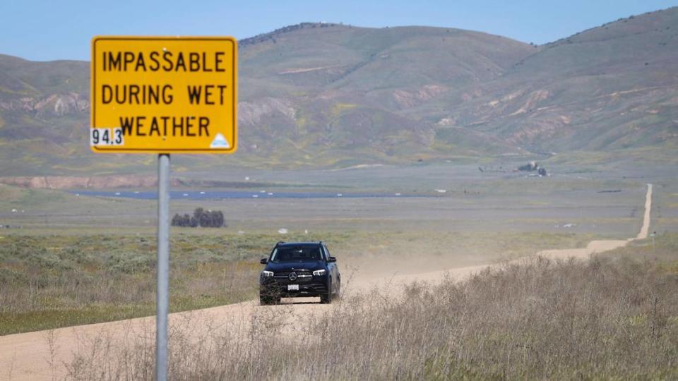 Gold wildflowers bloom on the Temblor Range as a car drives on Seven Mile Road in California Valley on April 3, 2024. David Middlecamp/dmiddlecamp@thetribunenews.com