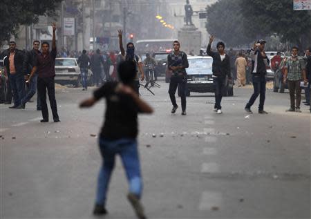 An anti-Mursi protester throws a stone at supporters of ousted Egyptian President Mohamed Mursi at Tahrir Square in Cairo December 1, 2013. REUTERS/Amr Abdallah Dalsh