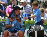 A ball boy gives a bottle of water to Novak Djokovic of Serbia during a break in his men's semi-final match against Ernests Gulbis of Latvia at the French Open tennis tournament at the Roland Garros stadium in Paris June 6, 2014. REUTERS/Vincent Kessler (FRANCE - Tags: SPORT TENNIS)