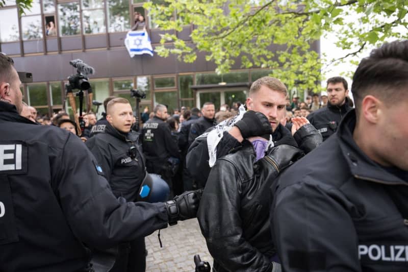 Police officers remove protesters outside the camp during a pro-Palestinian demonstration by the "Student Coalition Berlin" group in the theater courtyard of the Free University of Berlin. The participants occupied the square with tents on Tuesday morning. Sebastian Christoph Gollnow/dpa