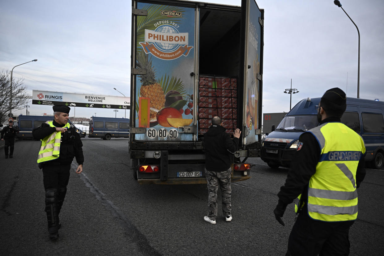 Gendarmes check the load of a truck arriving at Rungis wholesale food market, southern Paris, in Rungis on January 28, 2024. Farmers from the Lot-et-Garonne region, one of the hotspots of the protest movement, have already announced their intention to blockade the massive Rungis wholesale food market south of the capital. French farmers are furious at what they say is a squeeze on purchase prices for produce by supermarket and industrial buyers, as well as complex environmental regulations. (Photo by JULIEN DE ROSA / AFP)