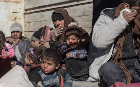 Families who escaped from the last two square-miles of Islamic State-held territory wait in a lorry to be taken to a camp for displaced people, near Baghuz - Credit: Sam Tarling