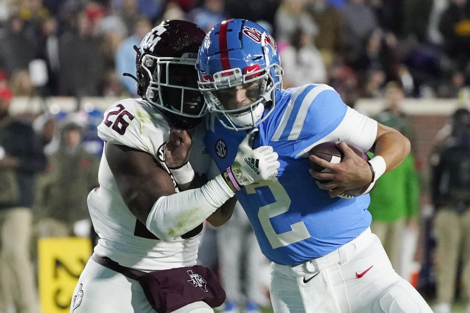 Texas A&M defensive back Demani Richardson (26) attempts to strip the ball away from Mississippi quarterback Matt Corral (2) during the first half of an NCAA college football game, Saturday, Nov. 13, 2021, in Oxford, Miss. (AP Photo/Rogelio V. Solis)