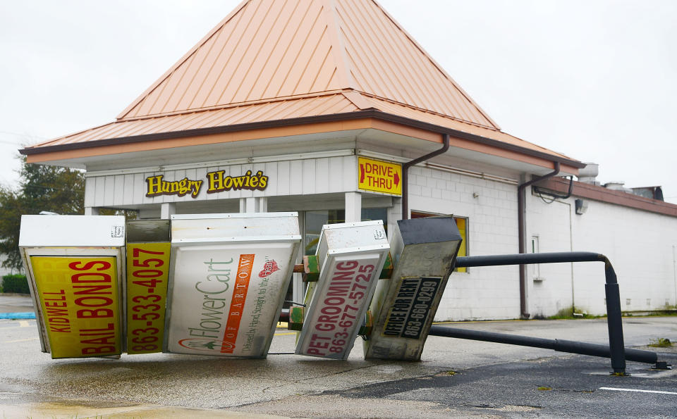A large commercial sign lies in a parking lot after being toppled by the heavy winds and rain.